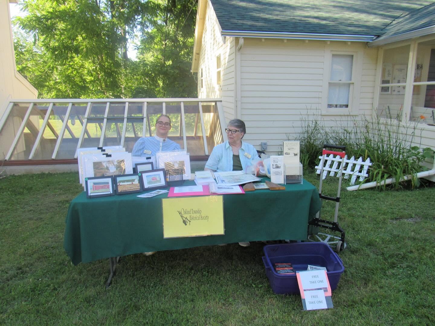 Two volunteers behind an Oakland Township Historical Society display table
